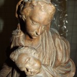 Brown wooden sculpture of woman holding small child